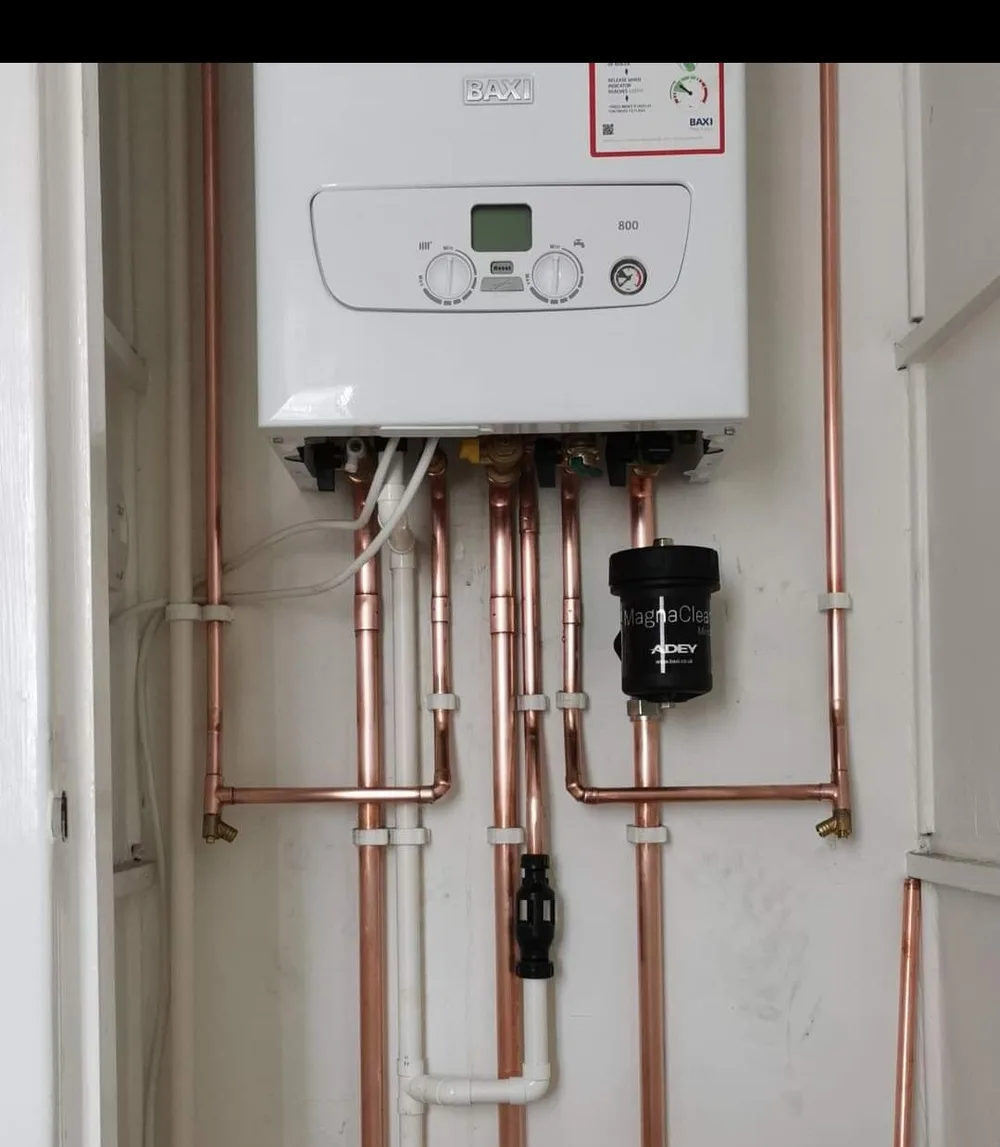 A newly installed combi boiler with fresh copper pipework and a magnetic filter